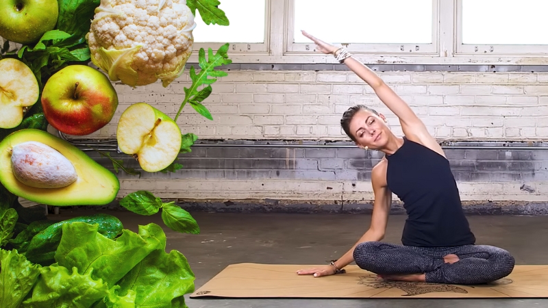 A Woman Doing Yoga with Fruits and Vegetables Beside Her, Showing the Yogic Diet