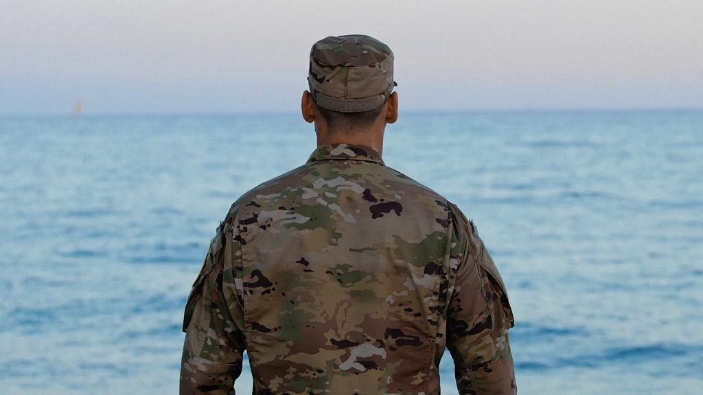 A Navy SEAL soldier stands in front of the ocean