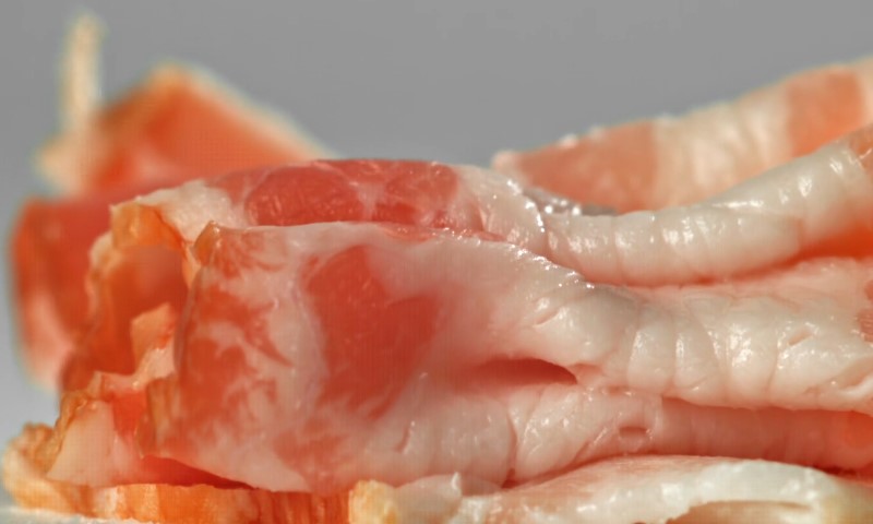Sliced bacon on a white surface