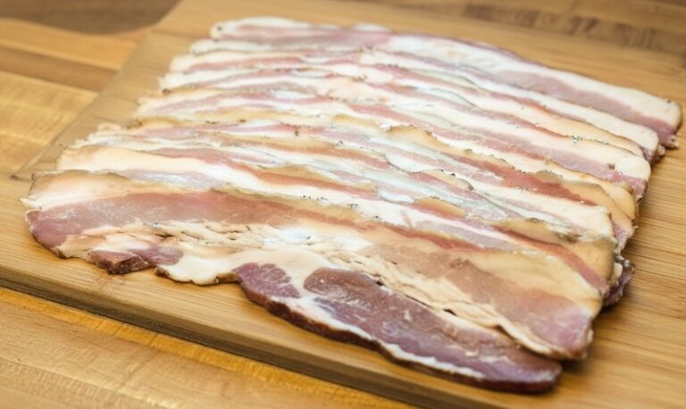 Sliced expired bacon on a wooden cutting board