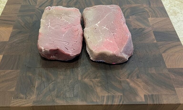 A pair of oxidized steaks on a wooden board