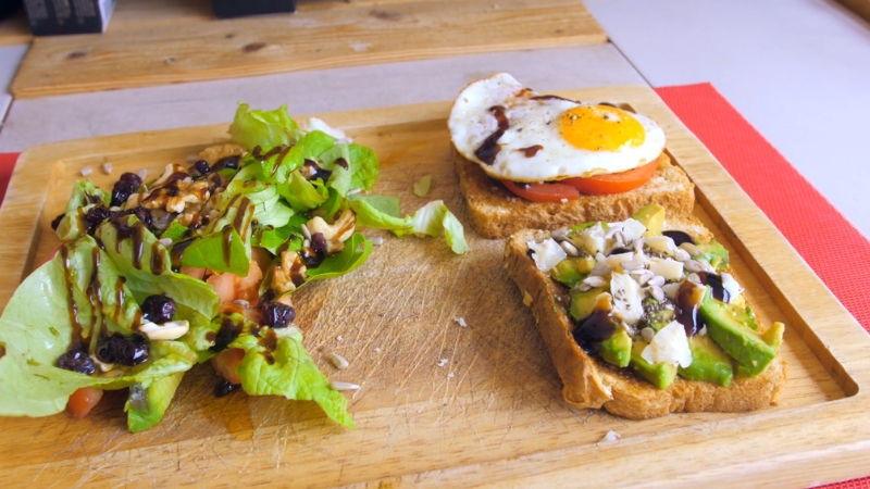 Avocado toast, fried egg, and a mixed green salad with nuts