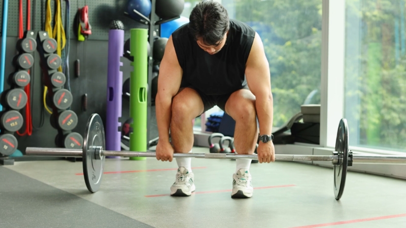 Powerlifter setting up for a deadlift in a gym